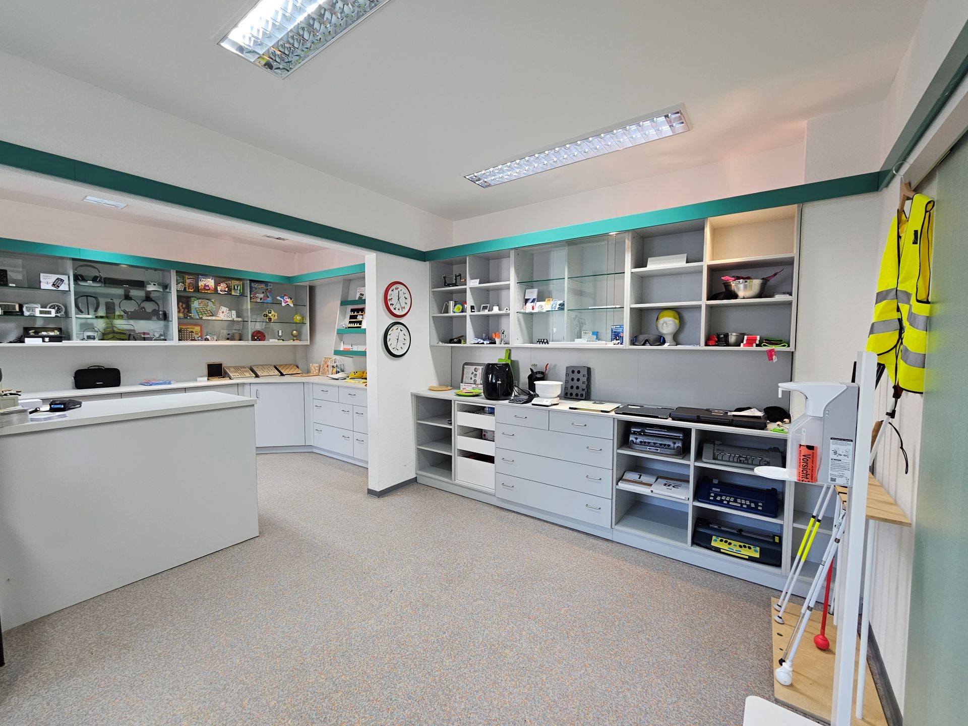 Blick in den Shop vom DHV mit Regalen, viel Platz in der Mitte und vielen Ausstellungsstücken an den Seiten und in den Schränken.