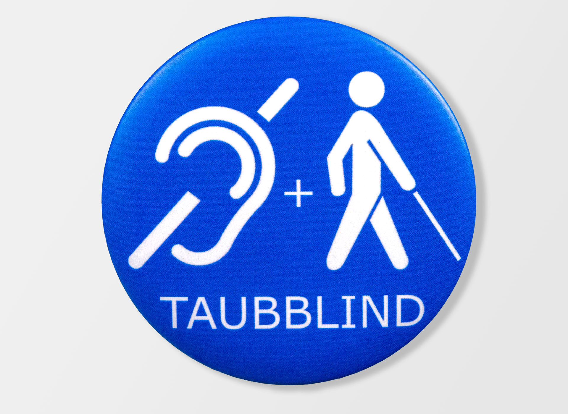 Ansicht auf eine blaue Plakette mit einem Männchen mit weißem Stock und ein durchgestrichenes Ohr