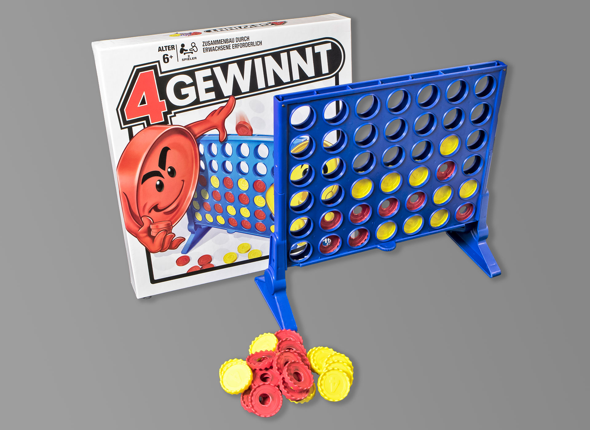 Ansicht auf das aufgebaute Spiel auf blauem Plastik mit gelben und roten Steinen und dem Spielkarton.